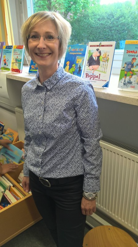 Frau Streiter , Frau in einer Bücherei neben Kinderbüchern